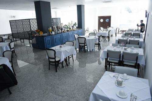 ein Esszimmer mit weißen Tischen und Stühlen in der Unterkunft Blue Open Hotel in Erechim