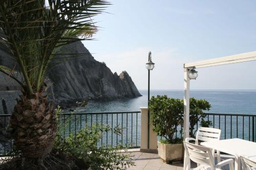 a patio with a table and chairs and the ocean at Asseu in Sestri Levante