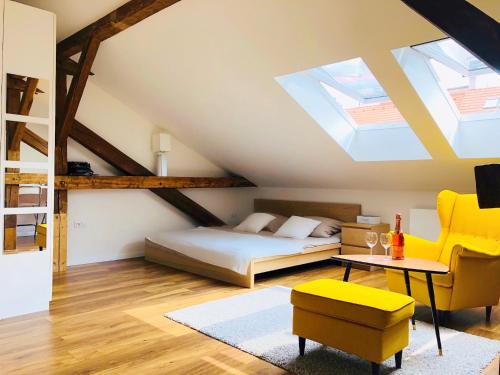 プラハにあるCharming loft apartmanの屋根裏のベッドルーム(ベッド1台、黄色い椅子付)