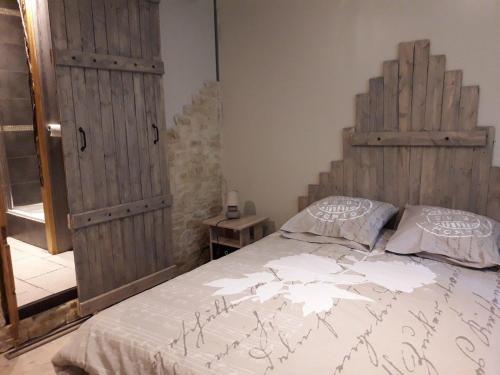 Un dormitorio con una cama con cabecero de madera. en Les farios, en Sarlat-la-Canéda