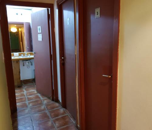 a hallway with two brown doors and a tile floor at Patagonia Jazz Hostel in San Carlos de Bariloche