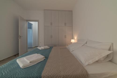 a bedroom with a large bed with towels on it at Gina's Cozy House in Kamilari