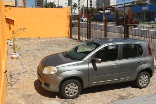 a small silver car parked next to a fence at Apart Hotel Casa Grande in Natal