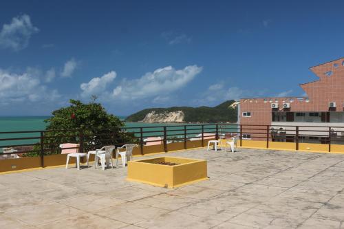 a group of chairs sitting on a patio overlooking the ocean at Apart Hotel Casa Grande in Natal