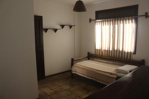 a small bedroom with a bed and a window at Apart Hotel Casa Grande in Natal