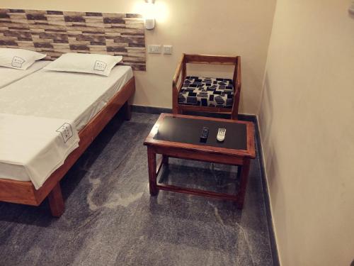 a bedroom with a bed and a table with a chessboard on it at Hotel Wins in Kanyakumari