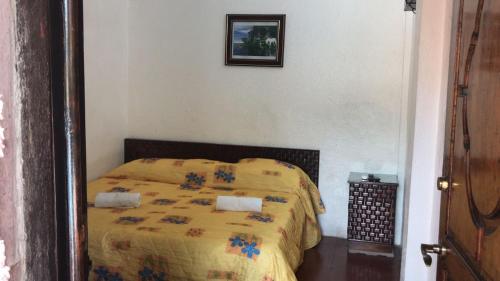 a bedroom with a bed with a yellow comforter at Casa Costera Miguel Alemán in Acapulco