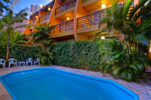 a swimming pool in front of a building at Apart Hotel Casa Grande in Natal