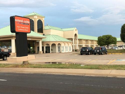 a building with a sign in front of a parking lot at Extend-a-Suites - Extended Stay, I-40 Amarillo West in Amarillo