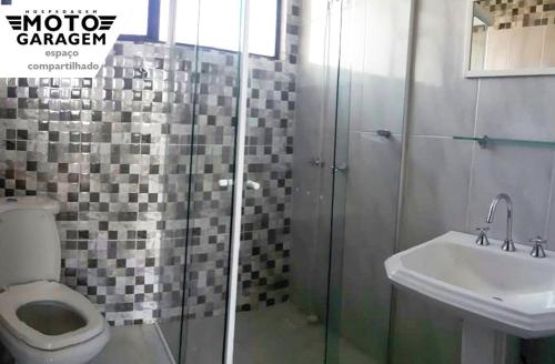 La salle de bains est pourvue d'une douche, de toilettes et d'un lavabo. dans l'établissement MotoGaragem, à Urubici