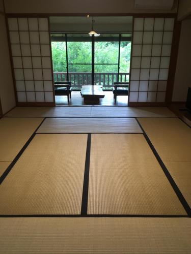 a room with a table and chairs in a building at 山荘 紗羅樹 Syaranoki in Yufuin