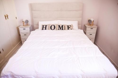 a bedroom with a large white bed with two night stands at Duquesa Seaview marina in Manilva