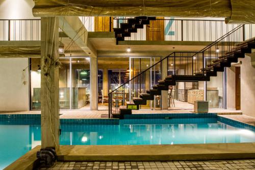 an indoor pool with a staircase and a house at Lazy Koala in Hikkaduwa
