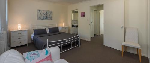 1 dormitorio con 1 cama, 1 silla y 1 sofá en Isle Of Palms Resort en Gold Coast