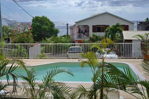 a swimming pool in front of a house at Les Merveilleux Flots de la Mer in Deshaies