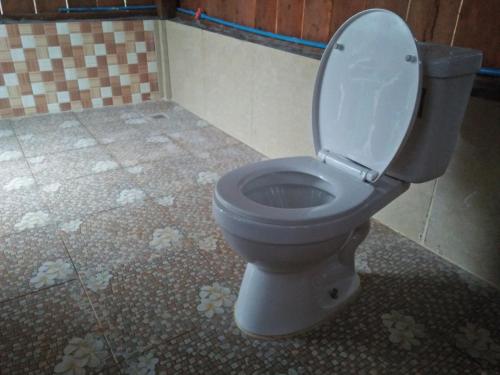 a toilet with the lid up in a bathroom at Tree Trails Homestay & Offers Jungle Trekk-Scooter For Rental in Banlung
