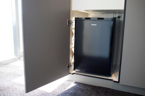 a refrigerator in a room with a door open at The Gateway Inn, Newcastle in Newcastle