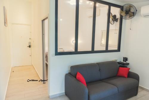 a living room with a couch and a window at Caribbean Appart' in Le Moule