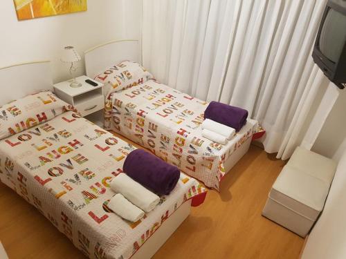 1 dormitorio con 2 camas individuales y TV en Suipacha Obelisco Departamento Familiar en Buenos Aires