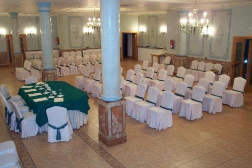 a banquet hall with white chairs and a green table at Hotel Florida in Albacete