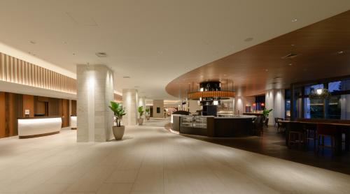 a lobby of a hotel with a bar and tables at Novotel Okinawa Naha in Naha
