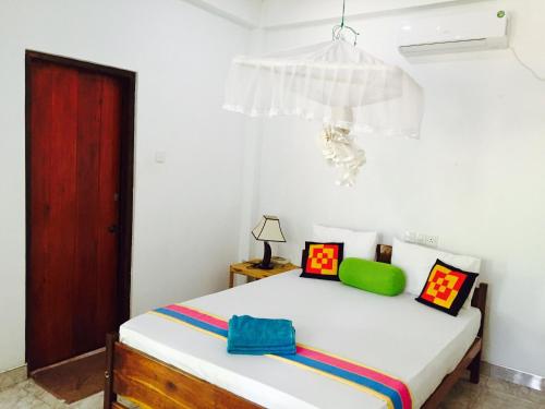 a bedroom with a bed and a red door at Sigiri Rainbow Lodge in Sigiriya