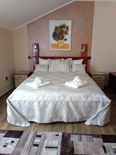 a bedroom with a large white bed with towels on it at Konak Kutko in Pančevo