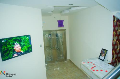 Habitación con TV en la pared y puerta en Pentagon Hotel and Suites, en Umueme