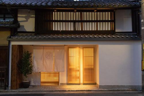 a white building with yellow doors and a window at Auberge AZABU in Kyoto