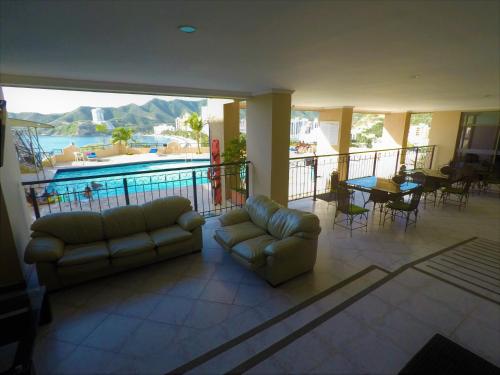 a living room with a couch and a swimming pool at Edificio El Peñon del Rodadero Apartamento Playa Rodadero in Santa Marta