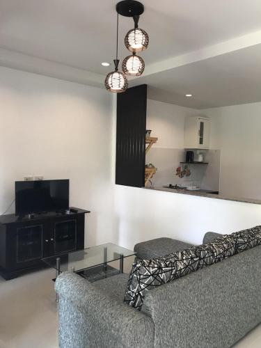a living room with a couch and a tv at Buncha Place in Bang Tao Beach
