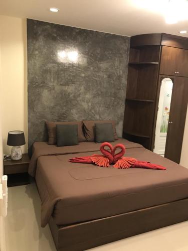 a bed with a red bow on top of it at Buncha Place in Bang Tao Beach