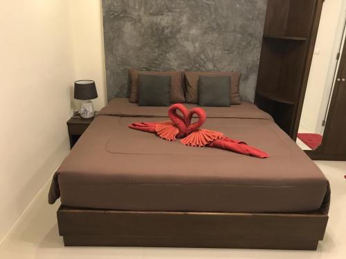 two beds with red ropes on them in a bedroom at Buncha Place in Bang Tao Beach