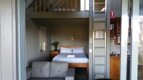a bed in a small room with a bunk bed at Great Ocean Road Cottages in Lorne