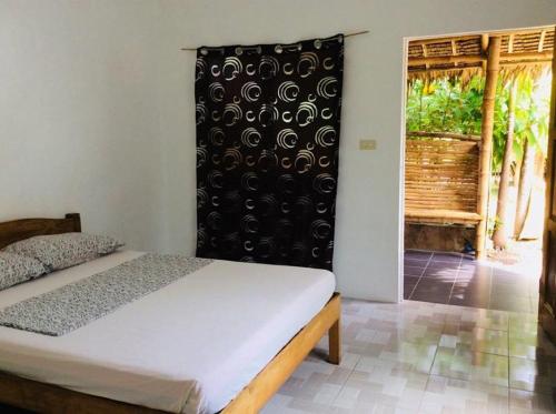 a bedroom with a bed and a sliding glass door at Stevrena Accommodations in Bantayan Island