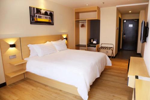 a large white bed in a hotel room at Rivertel in Teluk Intan