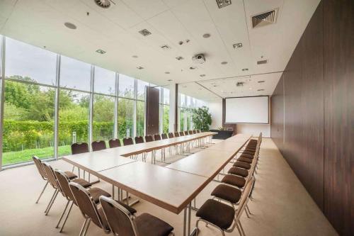 a conference room with a long table and chairs at Premier Kraków Hotel in Kraków