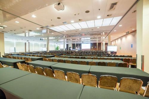 an auditorium with tables and chairs in a room at Premier Kraków Hotel in Kraków