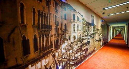 a hallway with a mural of buildings on the wall at Premier Kraków Hotel in Kraków