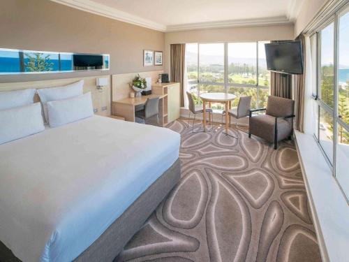 a hotel room with a bed and a room with a view at Novotel Wollongong Northbeach in Wollongong