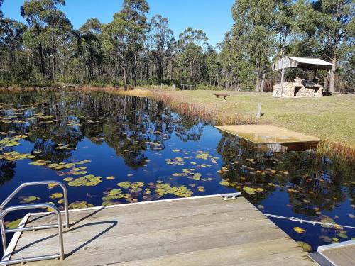 a dock on a lake with a gazebo at Bundera Lodge in Vacy