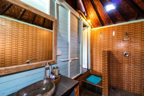 a bathroom with a sink and a shower at Song Lambung Beach Huts in Nusa Lembongan