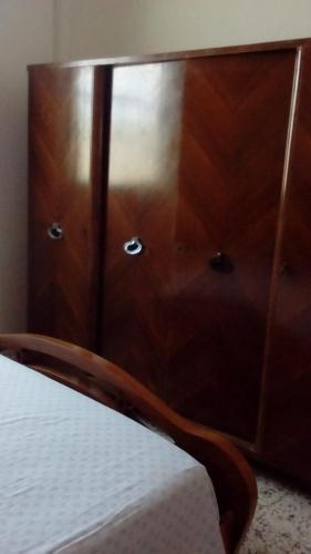a wooden cabinet with drawers on it next to a bed at Casa Angelo in Santa Maria Del Focallo
