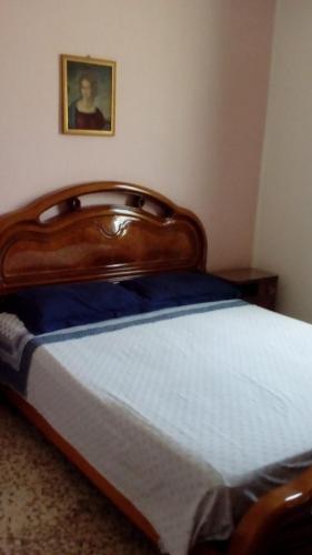 サンタ・マリア・デル・フォカッロにあるCasa Angeloのベッドルーム1室(木製ヘッドボード付)