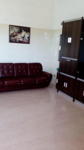 a living room with a brown leather couch and a cabinet at Casa Angelo in Santa Maria Del Focallo