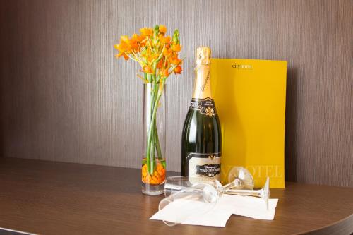a bottle of champagne and a vase of flowers on a table at City Hotel Tilburg in Tilburg