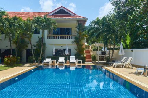 a swimming pool in front of a villa at Phuket Riviera Villas Hotel in Nai Harn Beach