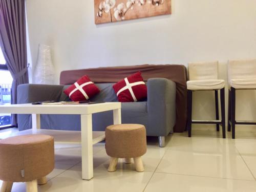a living room with a couch and a table and stools at Splendid Suite 2 Bedroom @ Sunway & PJ in Petaling Jaya