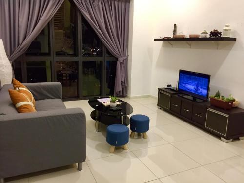 a living room with a couch and a tv at Splendid Suite 2 Bedroom @ Sunway & PJ in Petaling Jaya