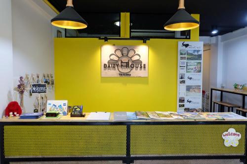 un mur jaune avec une table et un panneau. dans l'établissement Daizy House, à Chiang Mai